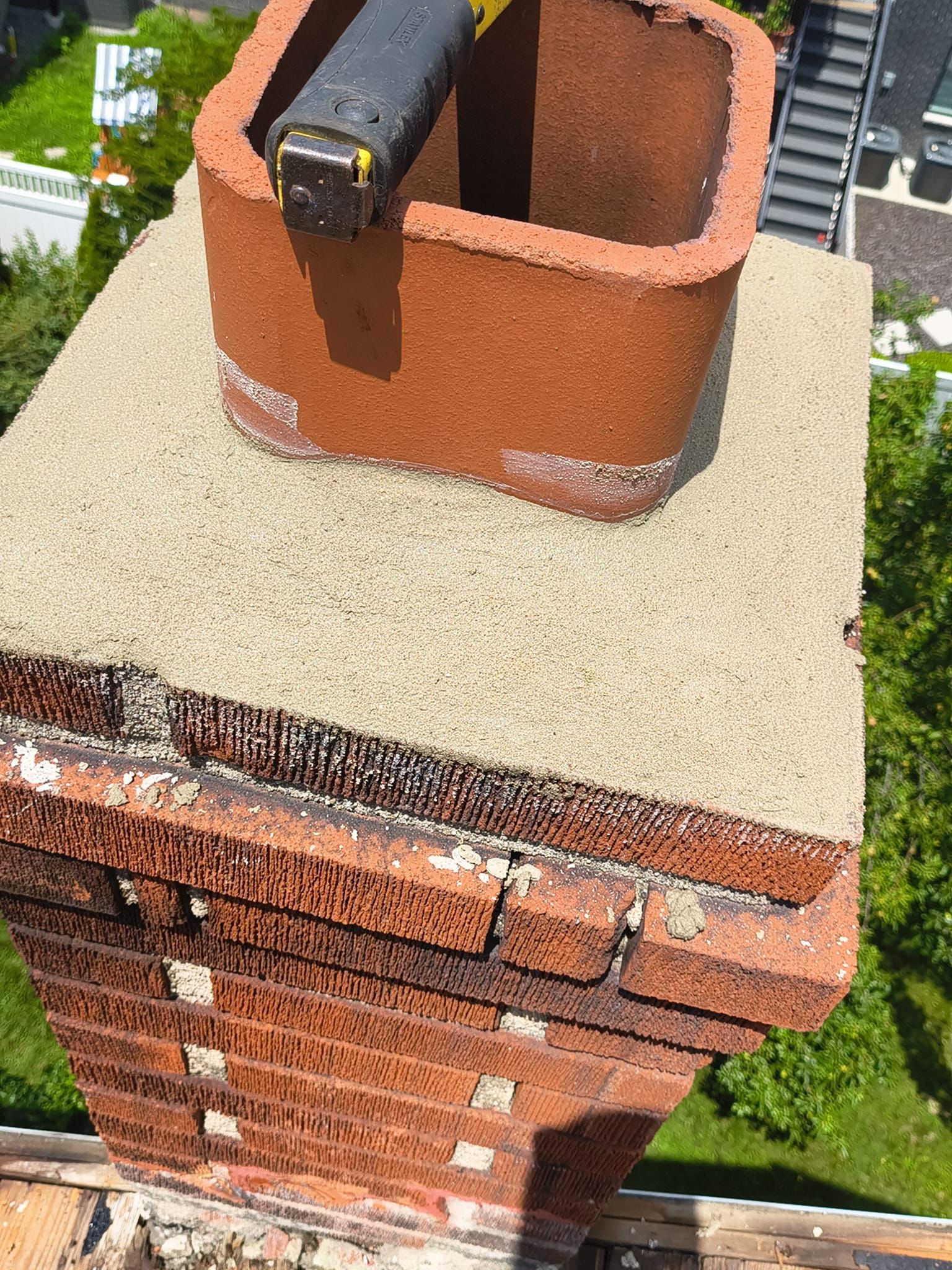 Freshly poured chimney crown with terracotta clay liner extension
